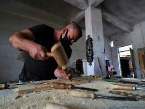 Eski ahşap kapılara sanatıyla hayat veriyor