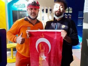 Enkazdan çıkan bayrağı duyarlı çalışana teslim etti