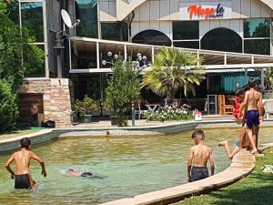 Denize ve paralı havuza gidemeyen çocuklar süs havuzlarında serinlemeye çalıştı
