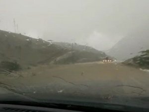 Rizeli sürücü yolun üzerinden akan dereye ve aralıksız yağan doluya rağmen yoluna böyle devam etti