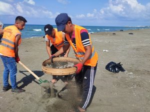 Petrol atıkları sahilde tırmık ve elek ile temizleniyor