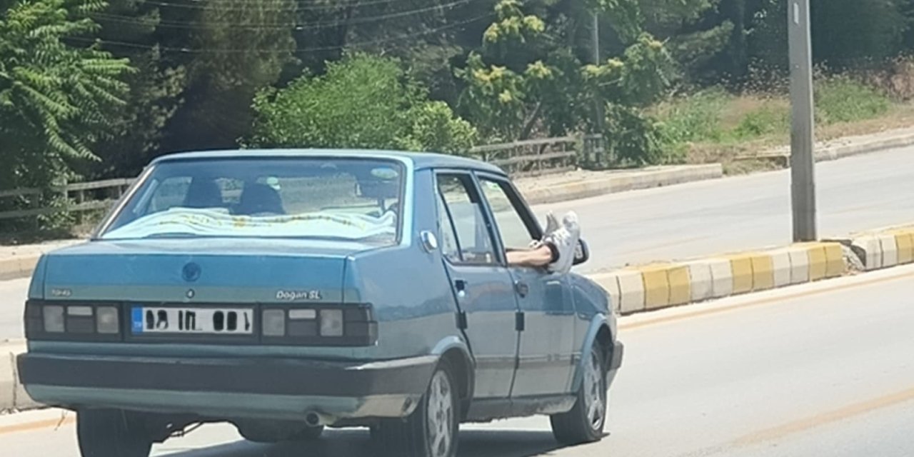 Ayaklarını camdan dışarı çıkartan yolcu trafiği riske attı