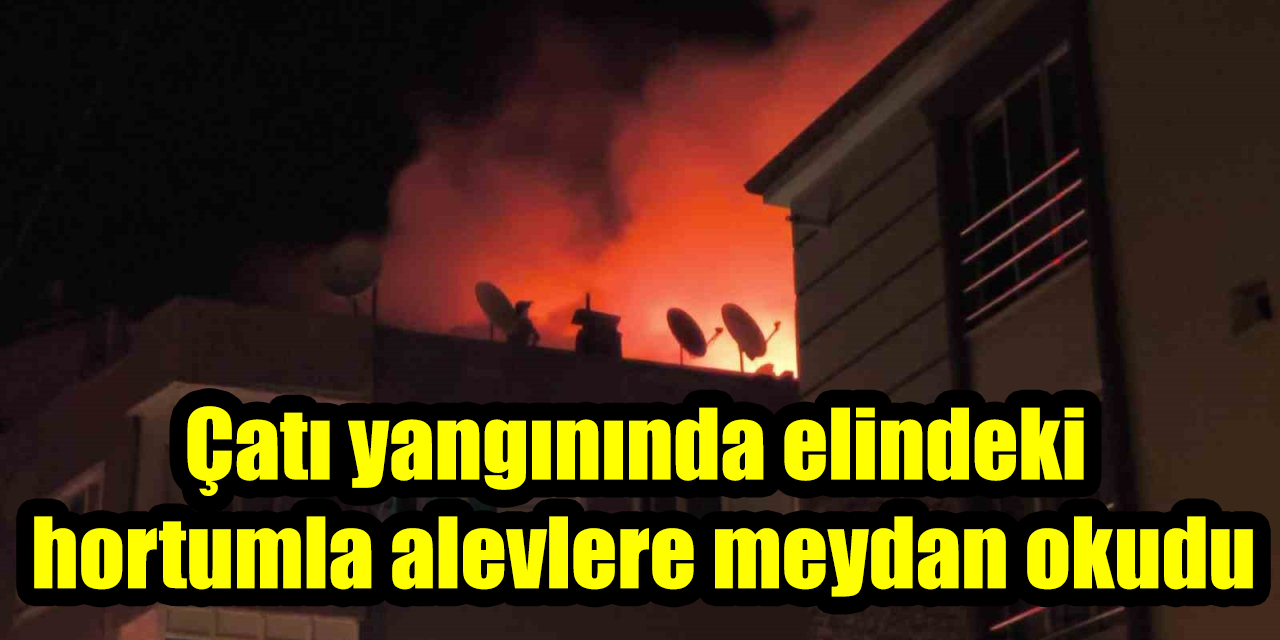 Çatı yangınında elindeki hortumla alevlere meydan okudu