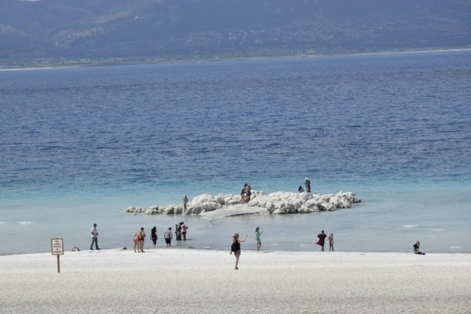 Suyu çekilen Salda gölü kıyısına yakın adaya yürüyerek geçiyorlar