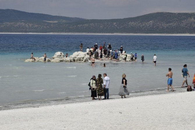 Suyu çekilen Salda gölü kıyısına yakın adaya yürüyerek geçiyorlar