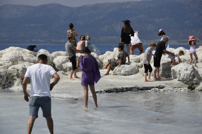 Suyu çekilen Salda gölü kıyısına yakın adaya yürüyerek geçiyorlar