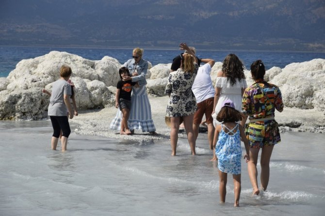 Suyu çekilen Salda gölü kıyısına yakın adaya yürüyerek geçiyorlar