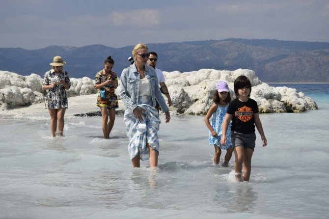 Suyu çekilen Salda gölü kıyısına yakın adaya yürüyerek geçiyorlar