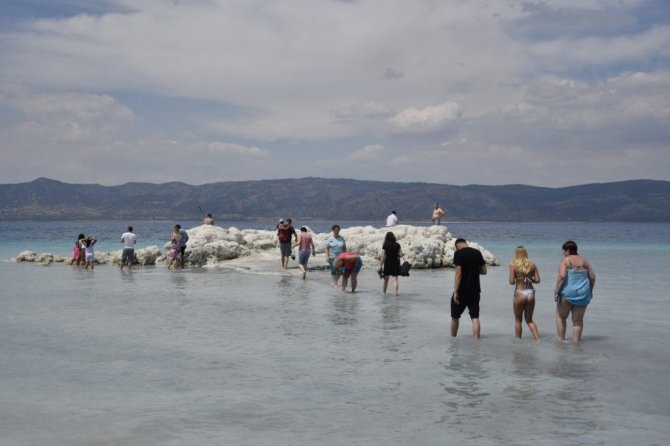 Suyu çekilen Salda gölü kıyısına yakın adaya yürüyerek geçiyorlar
