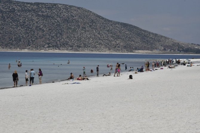 Suyu çekilen Salda gölü kıyısına yakın adaya yürüyerek geçiyorlar