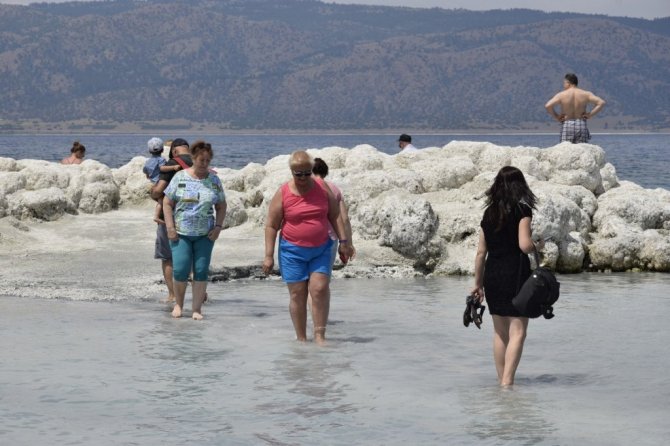 Suyu çekilen Salda gölü kıyısına yakın adaya yürüyerek geçiyorlar